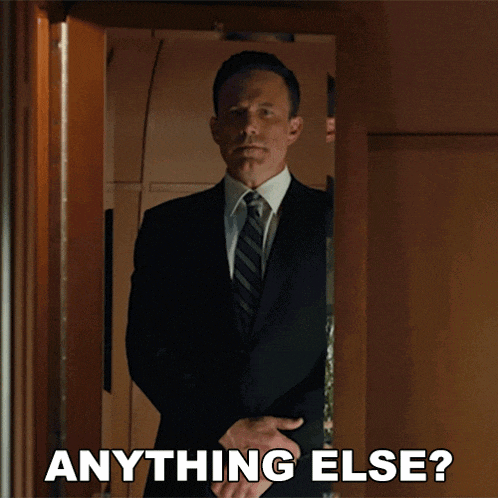 a man in a suit and tie is standing in a doorway with the words anything else below him