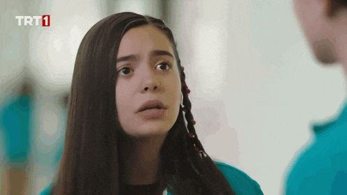 a girl in a blue shirt with trt1 written on the bottom right