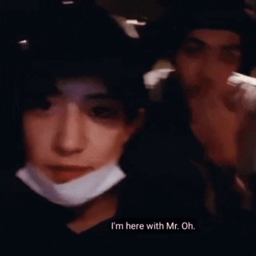a man wearing a mask says hello to another person