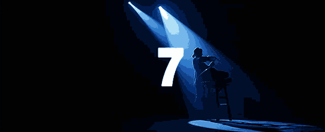 a spotlight shines on a person with the number 7 behind them