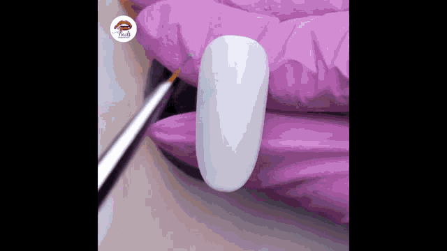 a close up of a nail being painted with a brush .