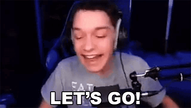 a man is sitting in front of a microphone and saying `` let 's go ! ''