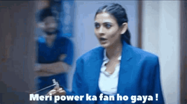a woman in a blue suit holds a hammer and says meri power ka fan ho gaya