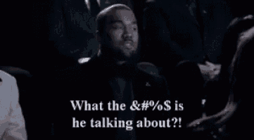 a man in a suit is talking to a woman in a crowd and says what the & # % $ is he talking about