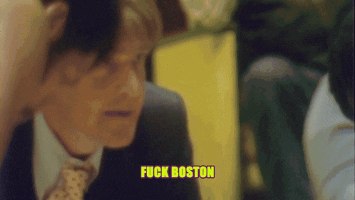 a man in a suit and tie says " fuck boston " in yellow letters
