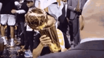 a man is kissing a trophy in front of a crowd .