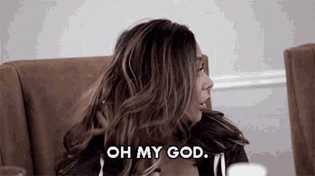a woman is sitting in a chair with her hair blowing in the wind and says oh my god