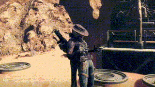 a man in a cowboy hat is holding a gun in front of a rocky cliff .