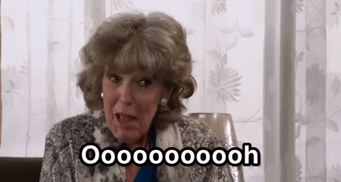 an elderly woman is sitting on a couch making a funny face and screaming .