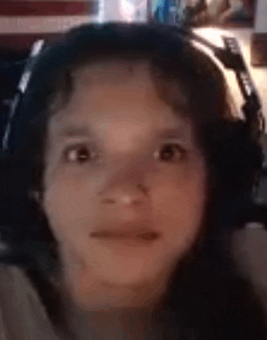 a young girl wearing headphones is making a face .