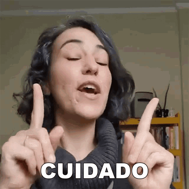 a woman is making a gesture with her hands and the word cuidado is above her