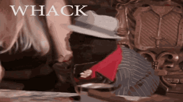 a man in a hat is sitting in a chair with the word whack written on the bottom