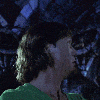 a man with a beard and a green shirt is making a surprised face