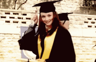 a woman in a graduation cap and gown is smiling and holding a diploma