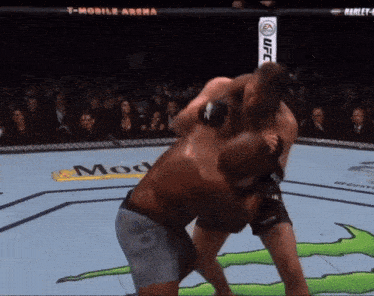 two men fighting in a boxing ring with a t-mobile arena banner in the background
