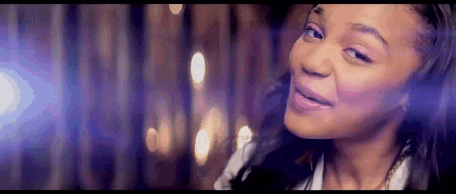 a close up of a woman 's face with lights behind her