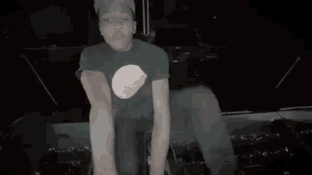 a man in a black shirt is holding a giant egg in his hands .