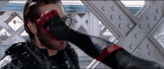 a man with blood on his face is being punched by a spiderman