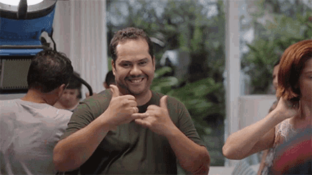 a man is giving a thumbs up in front of a woman
