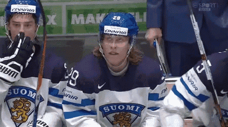 a hockey player wearing a jersey that says suomi sits on the bench
