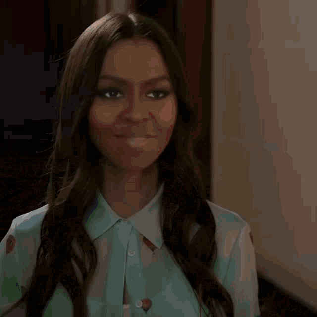a woman in a floral off the shoulder top is sitting at a desk