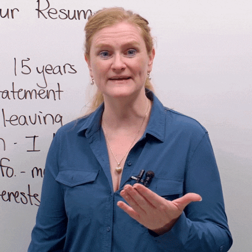 a woman stands in front of a white board with 15 years statement leaving written on it