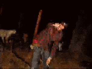 a man in a plaid shirt is holding a machete