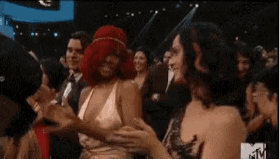 a group of women are dancing together in a crowd at a concert .