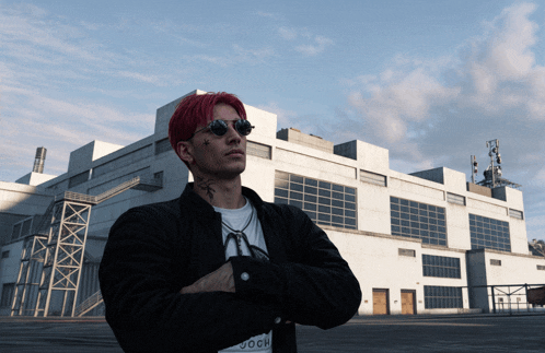 a man with red hair and a tattoo on his face stands in front of a large building