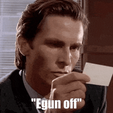 a man in a suit is holding a piece of paper in his hand and says " egun off " .