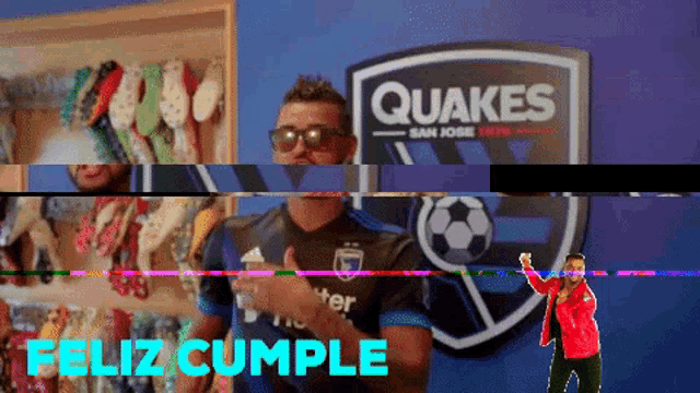 a man wearing sunglasses stands in front of a quakes sign