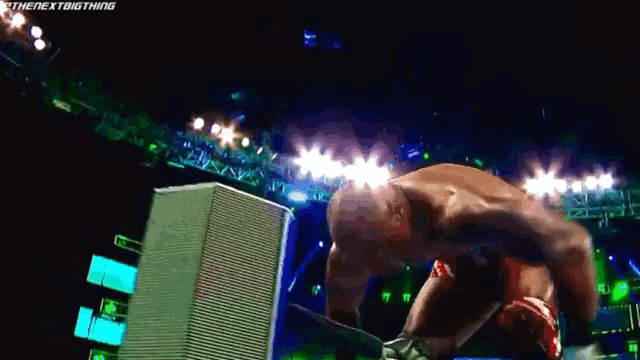 a wrestler is kneeling down in a wrestling ring with the words " the next big thing " on the bottom