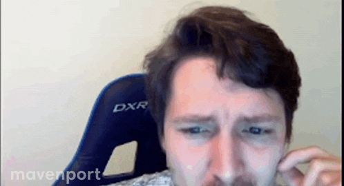 a man sitting in a blue dxr chair covering his ear