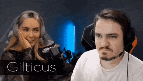 a man and a woman wearing headphones are sitting next to each other in front of a computer screen .