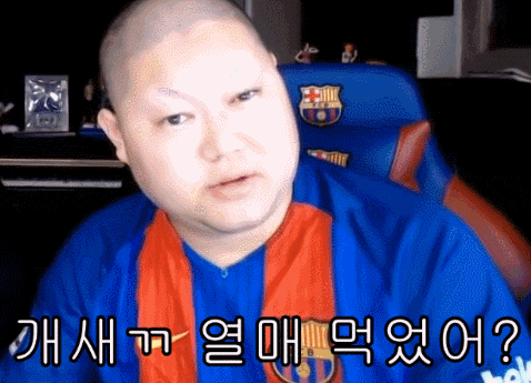 a bald man wearing a blue and red shirt with a scarf around his neck is sitting in a chair