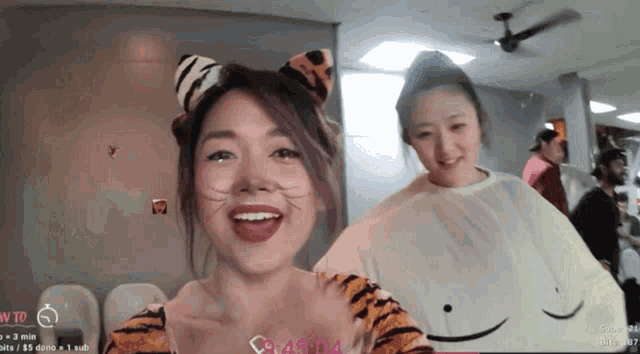 a woman in a tiger costume stands next to another woman in a white shirt