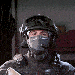 a man wearing a helmet and a mask with a red stripe on his chest