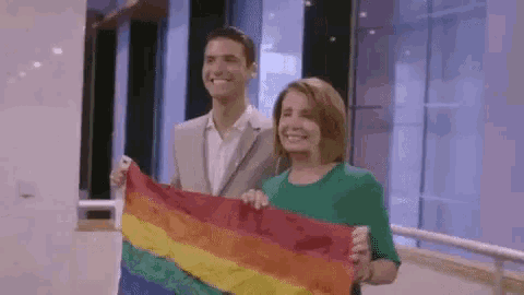 a man and a woman holding a rainbow flag