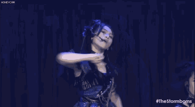 a girl is standing on a stage with her arm in the air .