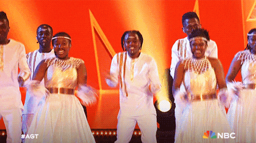 a group of people are dancing on a stage with nbc in the corner