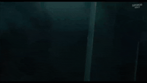 a close up of a monster in a dark room with smoke coming out of it 's mouth .