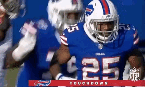 a football player with the number 25 on his jersey is being tackled by another player