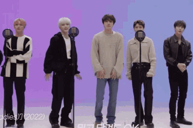 a group of young men standing in front of microphones with the year 2022 on the bottom right
