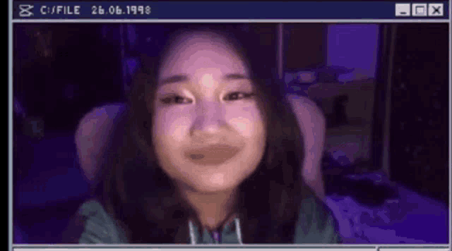 a girl is sitting in front of a computer screen with the date 26.06.1998 on it .