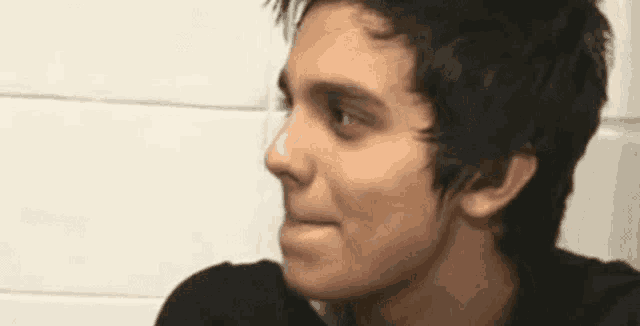a close up of a young man 's face with a slight smile on his face .