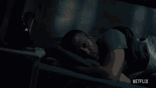 a man laying on a bed with netflix written on the bottom right