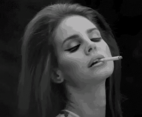 a woman with long hair is smoking a cigarette