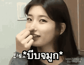 a woman is holding her nose while making a funny face in a black and white photo .