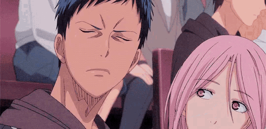 a man and a girl are sitting next to each other in a crowd .