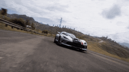 a white sports car is driving down a road